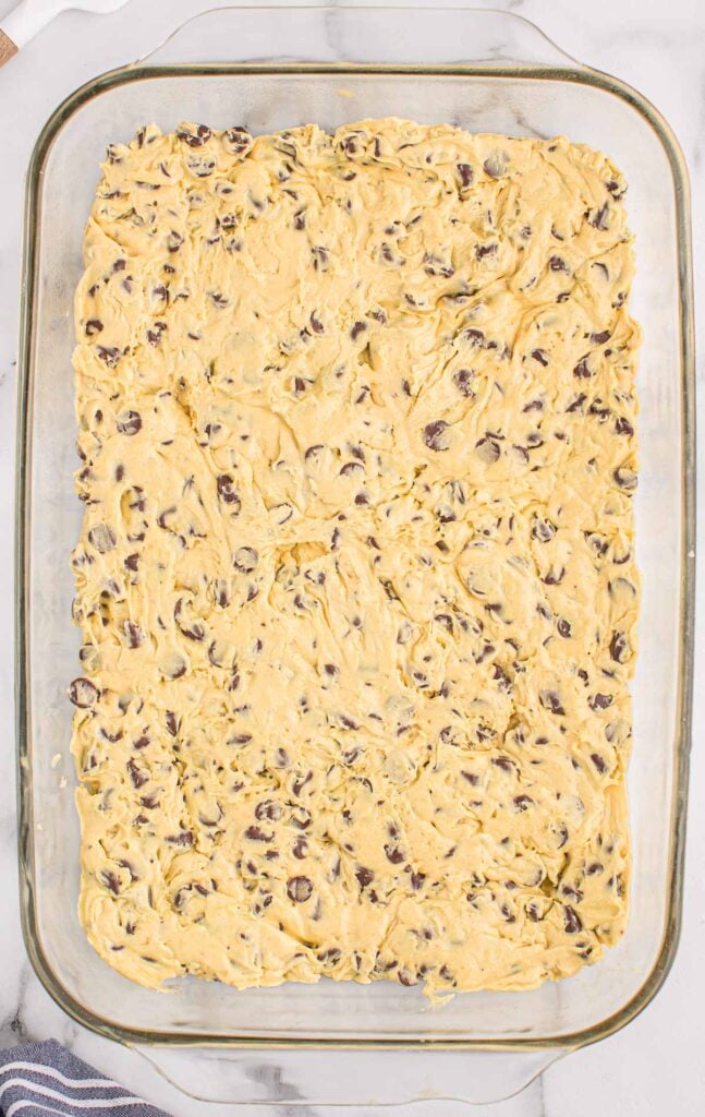 batter spread out in a 9 by 13 baking dish